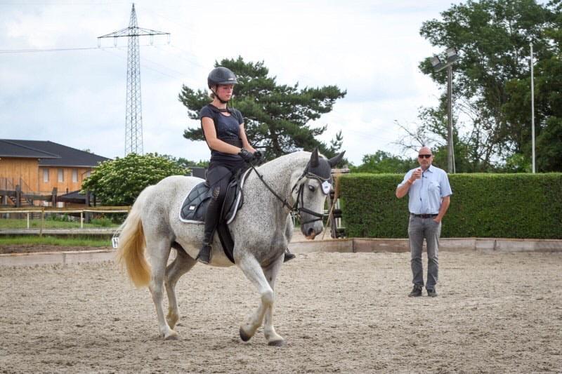Anouk Hagen auf ihrem Pferd Magic und im Hintergrund Trainer Mario Schreiber